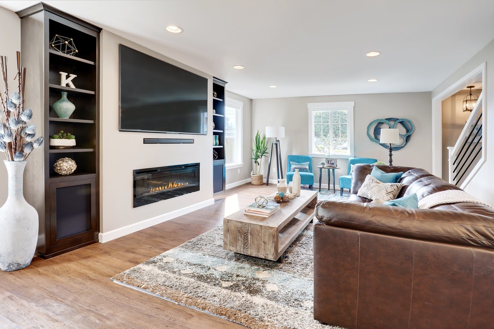 Abgetrenntes Klassisches Wohnzimmer mit beiger Wandfarbe, braunem Holzboden, Gaskamin, Kaminumrandung aus Metall, Multimediawand und braunem Boden in Seattle