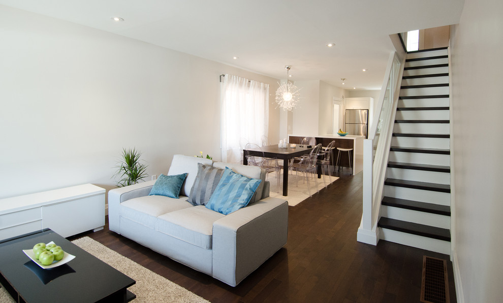 Small modern open plan living room in Toronto with grey walls and dark hardwood flooring.