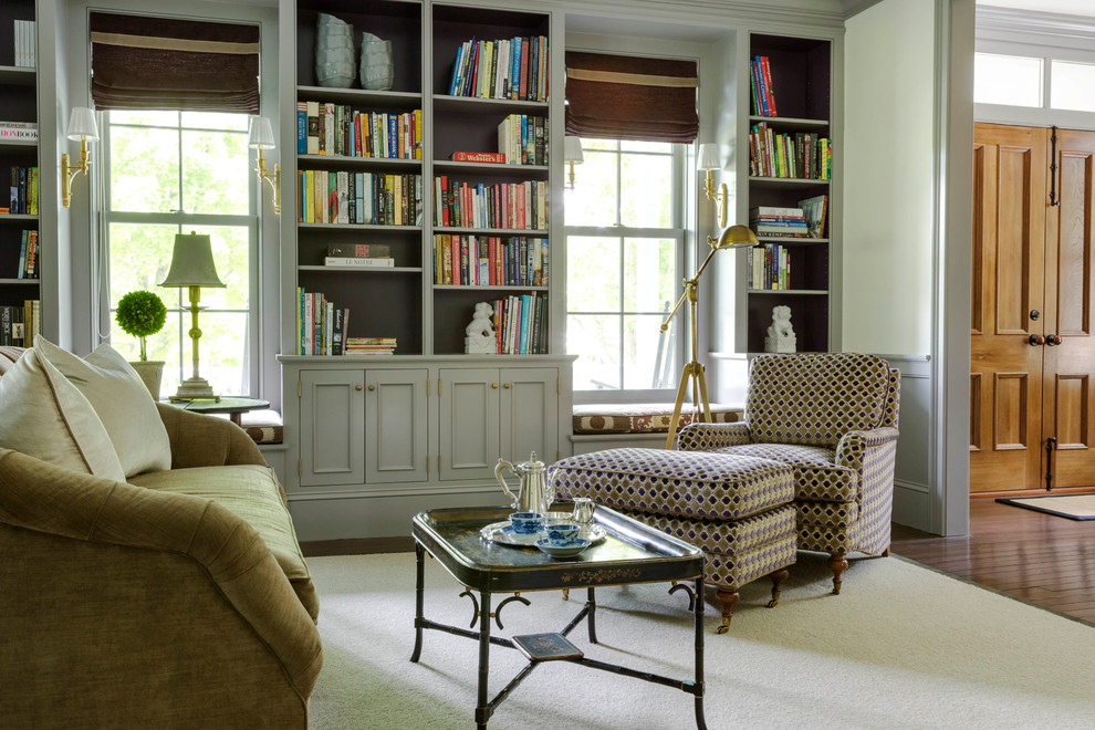 Cette photo montre un salon chic de taille moyenne et fermé avec une bibliothèque ou un coin lecture, un mur gris et parquet foncé.