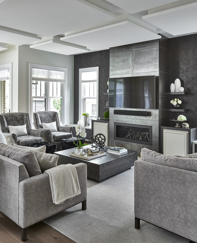 Foto de salón abierto actual con paredes grises, suelo de madera en tonos medios, chimenea lineal, televisor colgado en la pared y suelo marrón