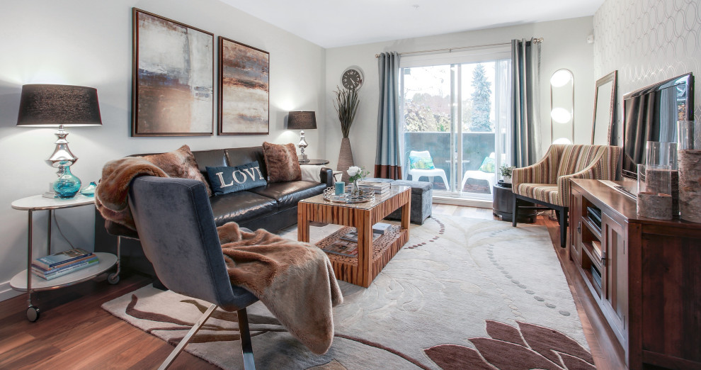 Immagine di un soggiorno design di medie dimensioni e aperto con pareti grigie, pavimento in legno massello medio, TV autoportante e pavimento marrone
