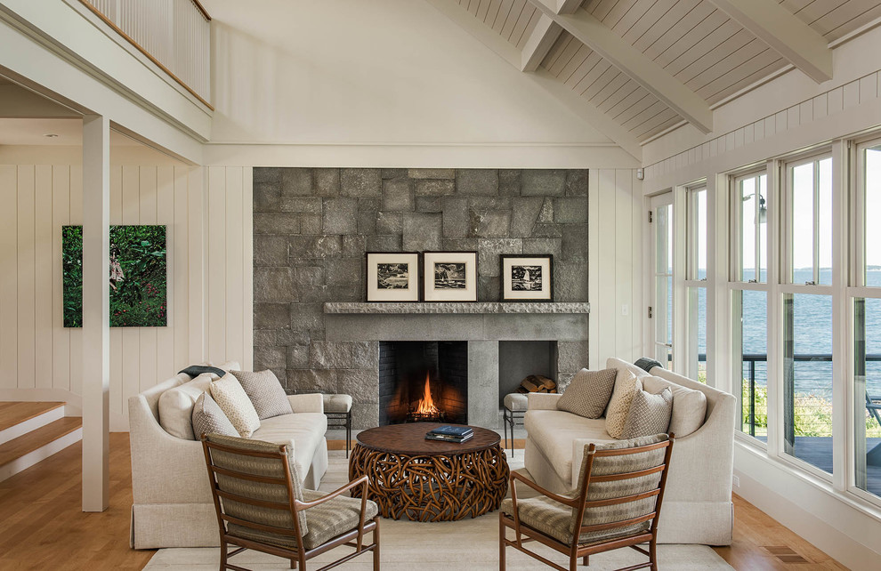 This is an example of a large coastal formal open plan living room in Portland Maine with white walls, light hardwood flooring, a standard fireplace and a stone fireplace surround.