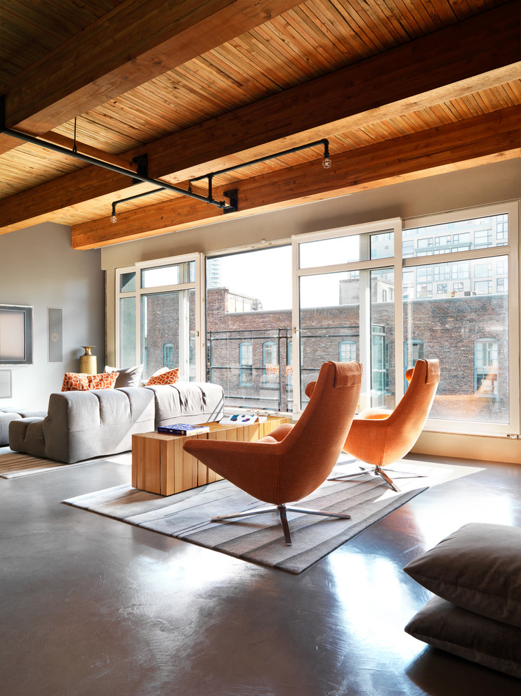 Идея дизайна: открытая гостиная комната среднего размера в современном стиле с бетонным полом, телевизором на стене и серыми стенами без камина