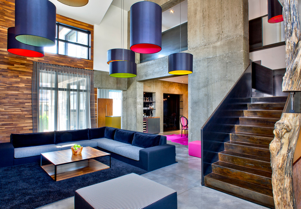 Стильный дизайн: открытая гостиная комната в современном стиле с разноцветными стенами и бетонным полом - последний тренд