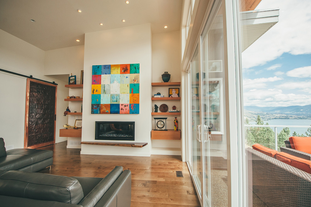 Aménagement d'un grand salon moderne ouvert avec une salle de réception, un mur beige, un sol en bois brun, une cheminée ribbon, un manteau de cheminée en métal, aucun téléviseur et un sol beige.