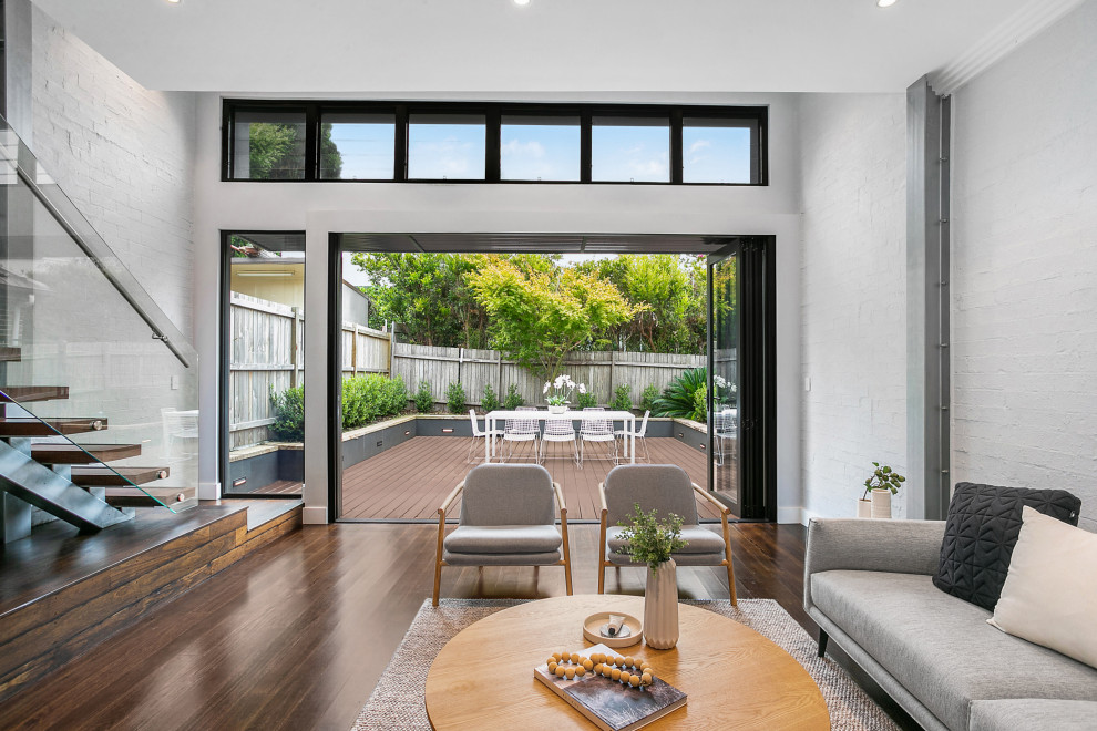 Großes, Offenes Modernes Wohnzimmer mit weißer Wandfarbe, braunem Holzboden und braunem Boden in Sydney