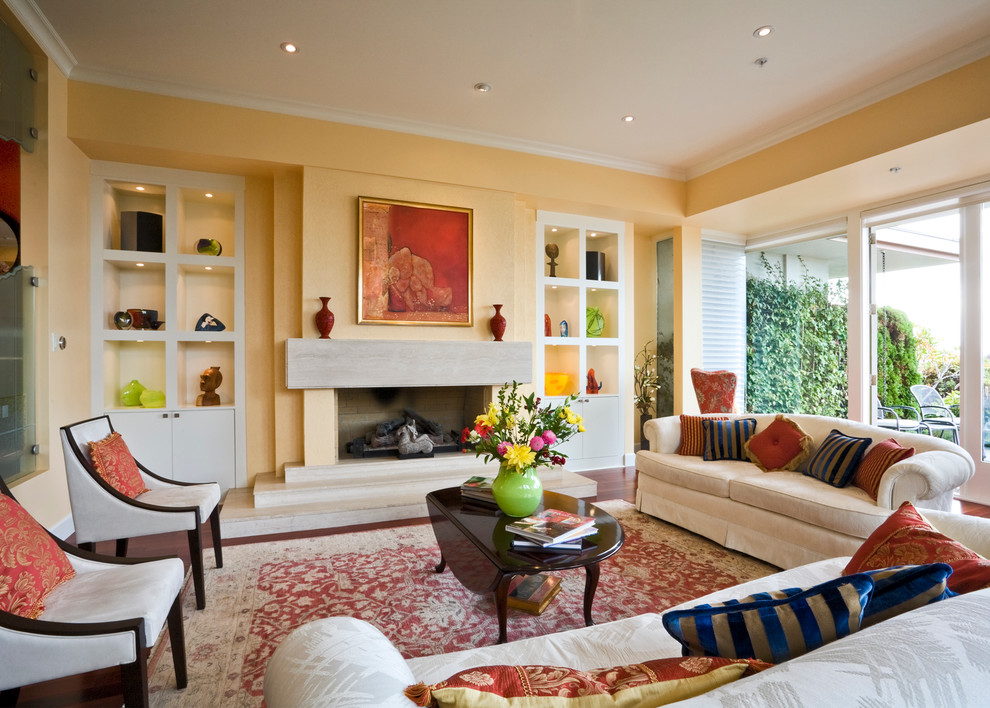 Großes, Repräsentatives, Offenes Klassisches Wohnzimmer mit gelber Wandfarbe, Kamin, braunem Holzboden und Kaminumrandung aus Beton in Vancouver