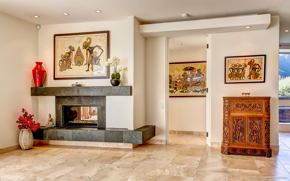 Example of an island style travertine floor living room design in Hawaii with white walls, a two-sided fireplace and a stone fireplace