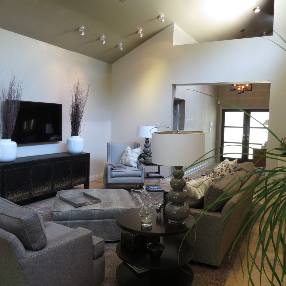Ejemplo de salón abierto contemporáneo de tamaño medio con paredes blancas, suelo de madera clara y televisor colgado en la pared