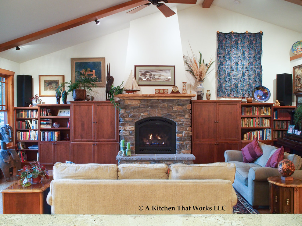 Foto de biblioteca en casa abierta de estilo americano de tamaño medio con paredes blancas, pared multimedia, suelo de madera en tonos medios, todas las chimeneas, marco de chimenea de piedra y suelo marrón