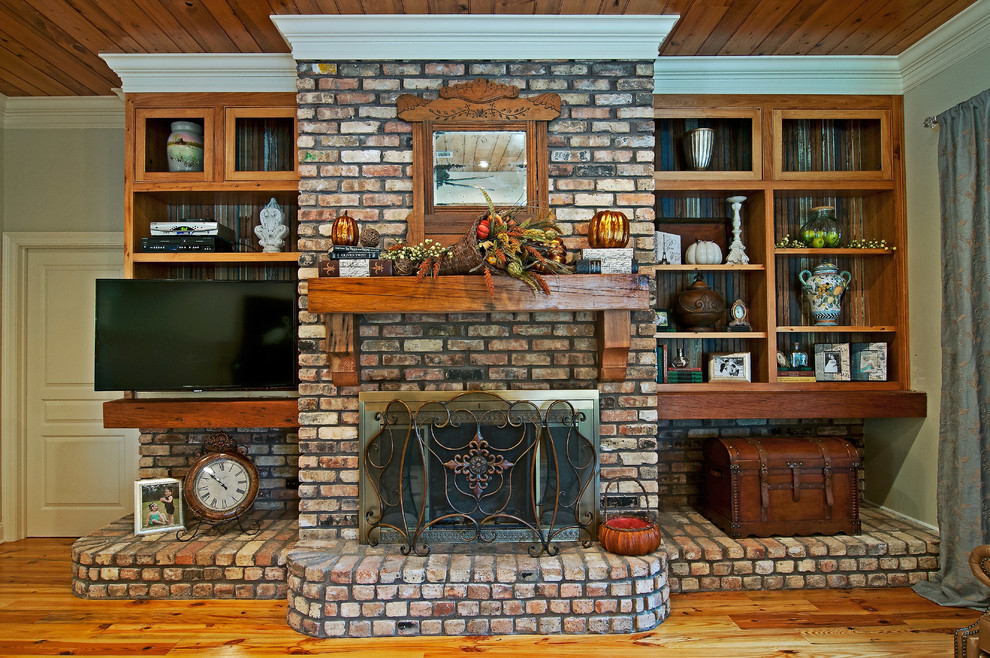 Cette image montre un salon traditionnel de taille moyenne et ouvert avec un mur beige, parquet clair, une cheminée standard, un manteau de cheminée en brique et un téléviseur indépendant.