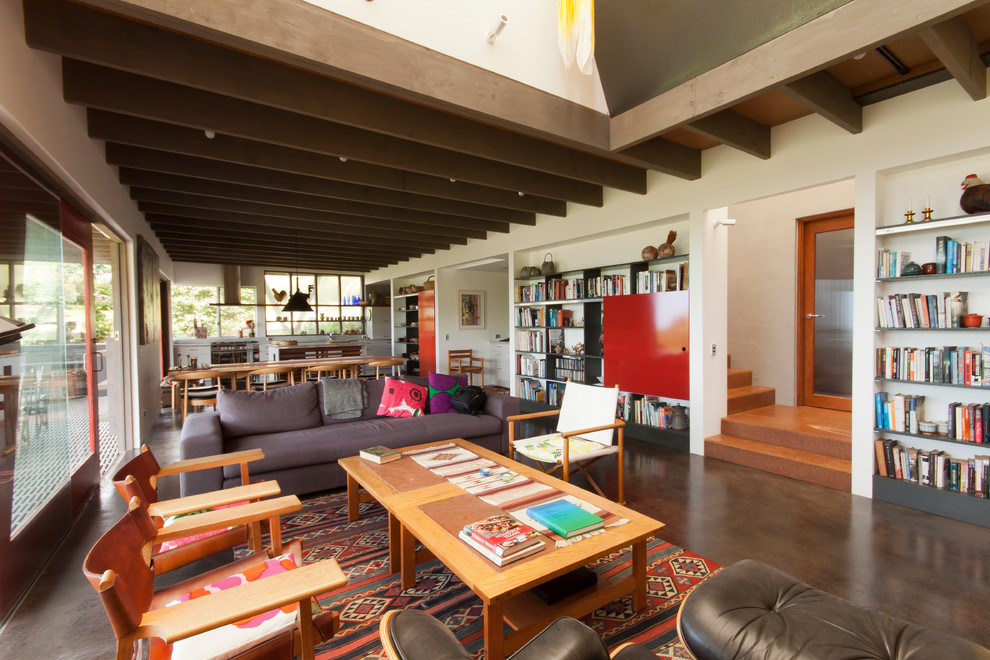 Mittelgroßes, Offenes Stilmix Wohnzimmer mit weißer Wandfarbe, Betonboden, Kamin und Kaminumrandung aus Stein in Sunshine Coast