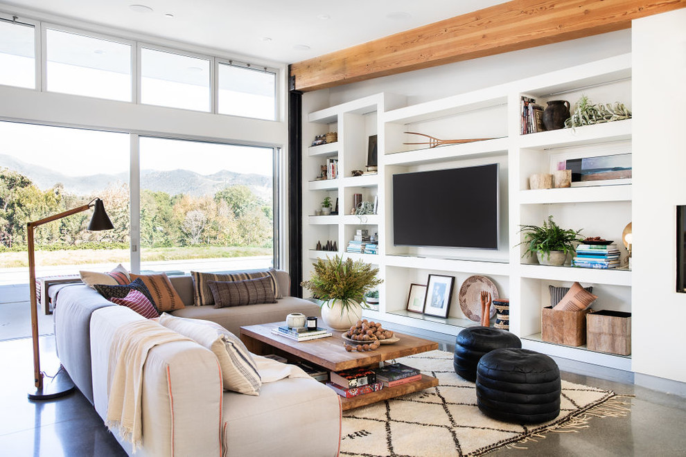 Esempio di un soggiorno minimal con pareti bianche, pavimento in cemento, TV a parete e pavimento grigio