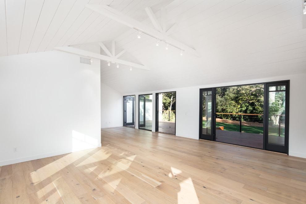 Mittelgroßes, Offenes Country Wohnzimmer mit weißer Wandfarbe, hellem Holzboden und TV-Wand in Los Angeles