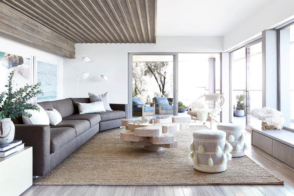 Contemporary living room in Los Angeles with white walls and light hardwood flooring.