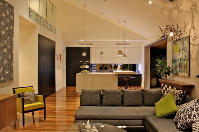 Idee per un soggiorno minimal con pareti bianche, pavimento in legno massello medio e TV nascosta