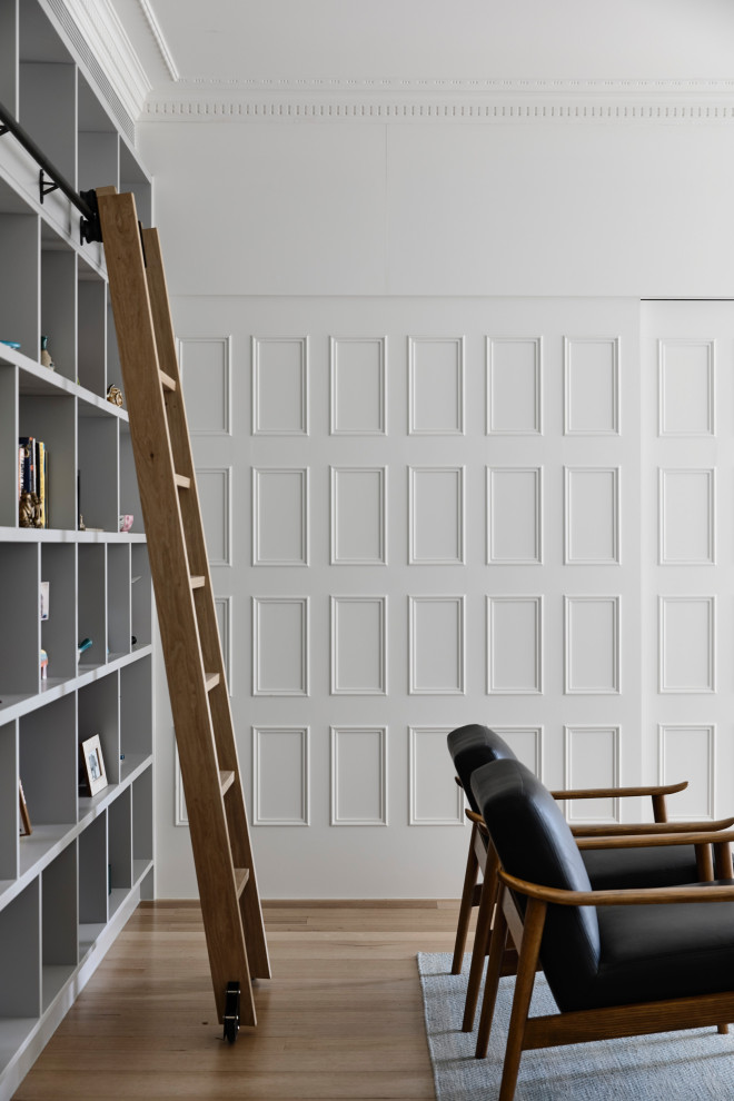 Mittelgroßes, Offenes Klassisches Wohnzimmer mit weißer Wandfarbe, braunem Holzboden, verstecktem TV und braunem Boden in Melbourne