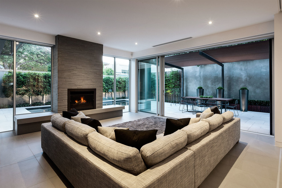 Стильный дизайн: гостиная комната в современном стиле с фасадом камина из камня, горизонтальным камином и ковром на полу - последний тренд