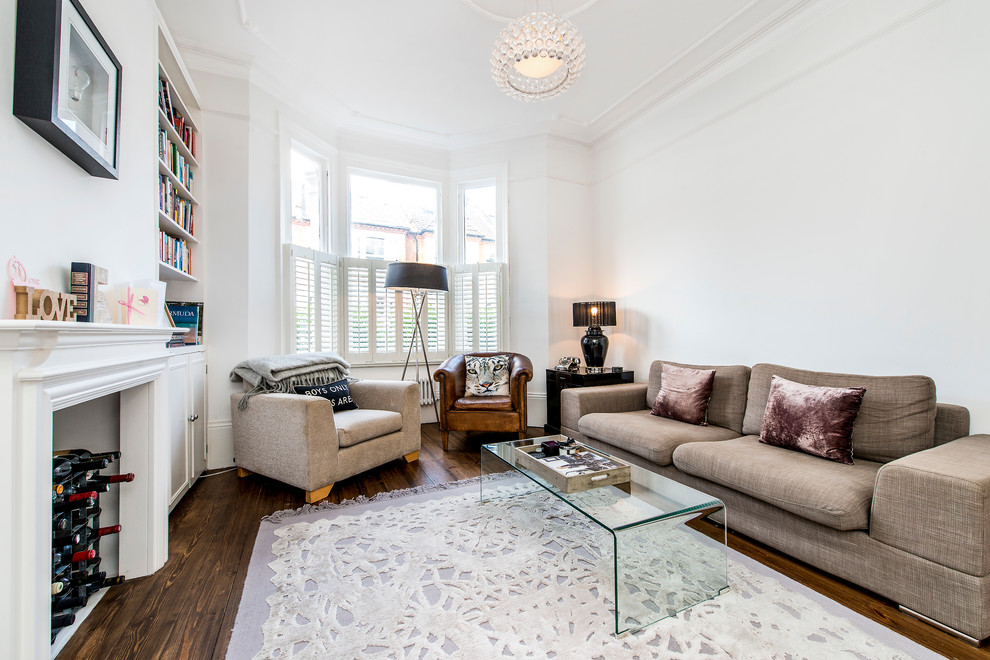 This is an example of a traditional living room in London with white walls, medium hardwood flooring, no tv and brown floors.