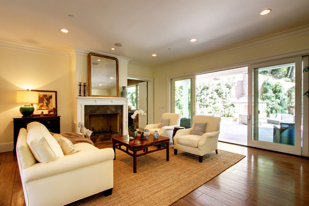 Cette image montre un salon traditionnel avec un mur beige et une cheminée standard.