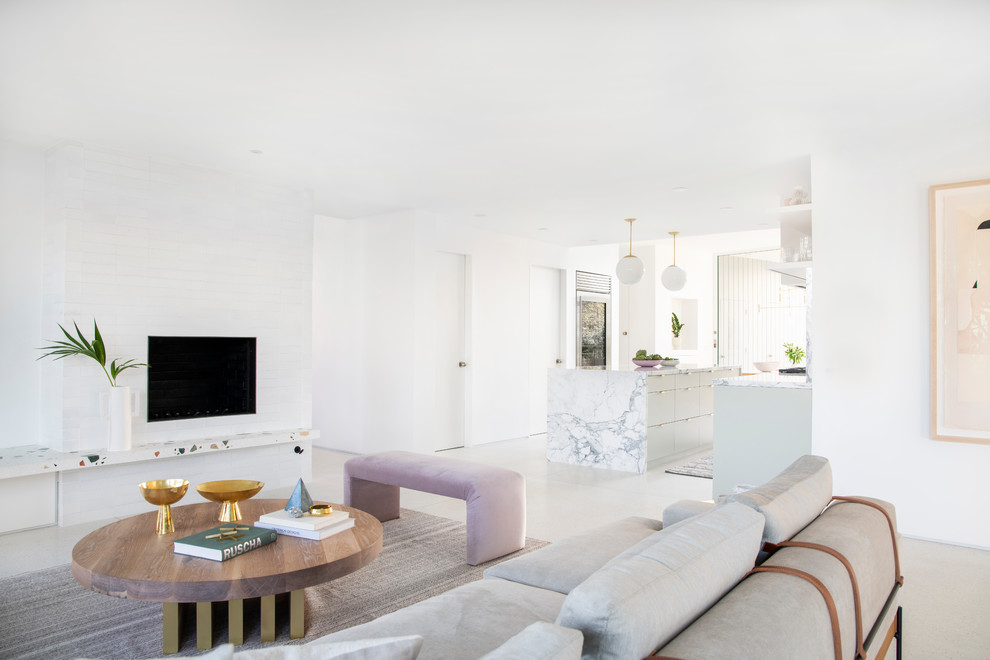 Стильный дизайн: гостиная комната в стиле ретро с белыми стенами и фасадом камина из кирпича - последний тренд