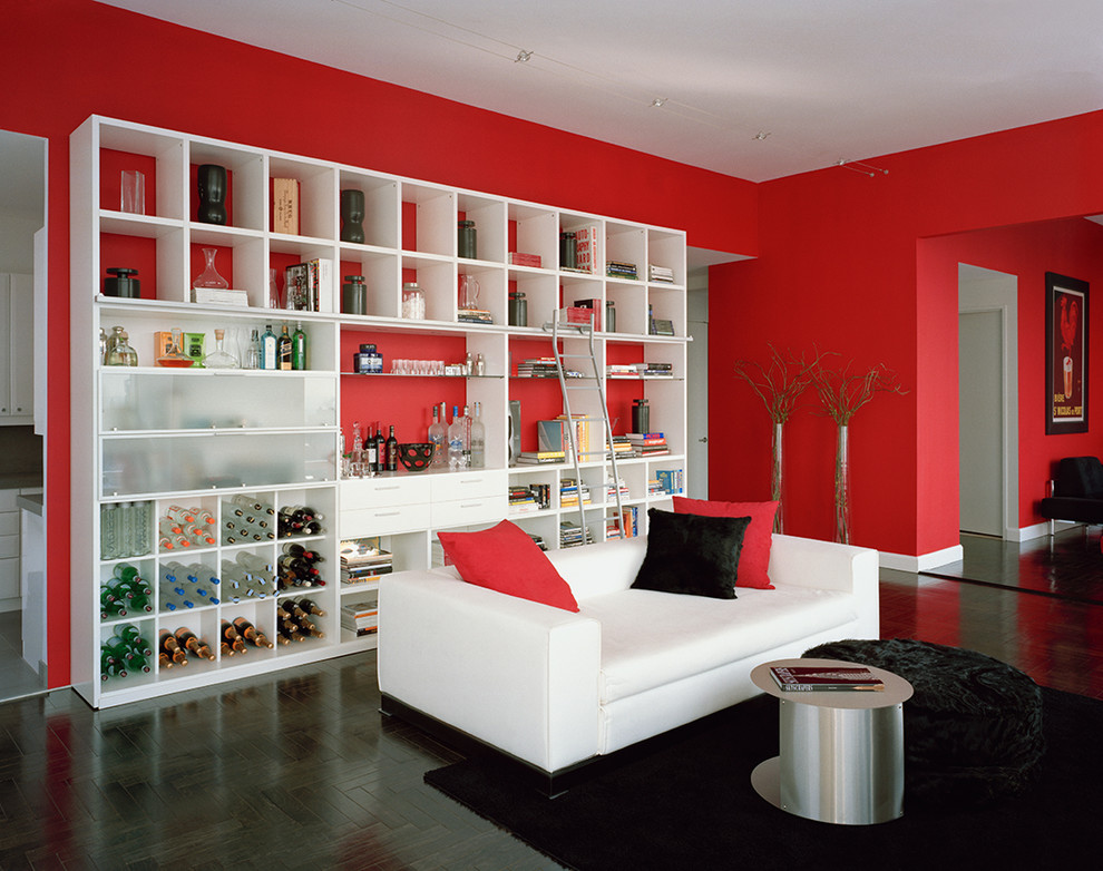 На фото: огромная гостиная комната в современном стиле с красными стенами и темным паркетным полом с