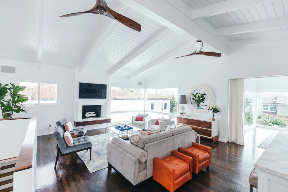 Example of a mid-sized transitional open concept medium tone wood floor living room design in Los Angeles with white walls, a hanging fireplace, a wood fireplace surround and a wall-mounted tv