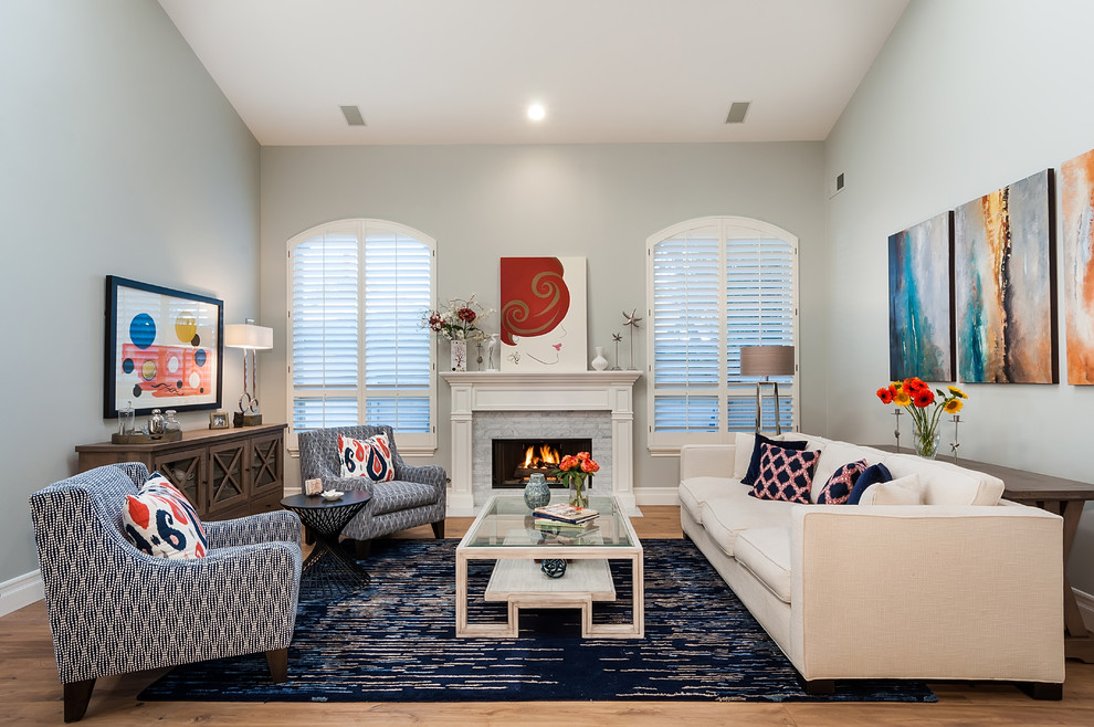 Design ideas for a large coastal open plan living room in Los Angeles with grey walls, light hardwood flooring, a standard fireplace, a stone fireplace surround and multi-coloured floors.