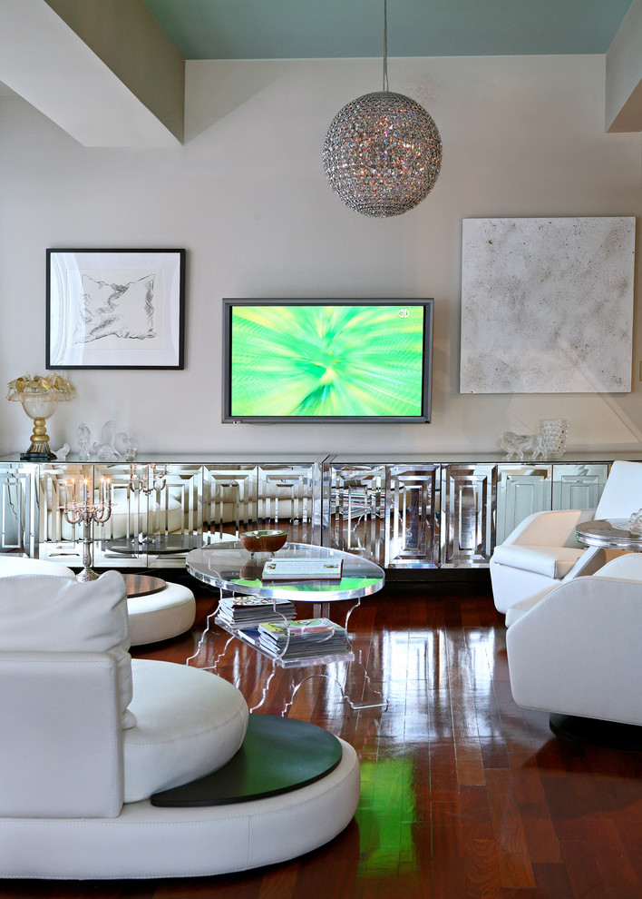 Diseño de salón abierto actual con paredes grises, suelo de madera oscura y televisor colgado en la pared