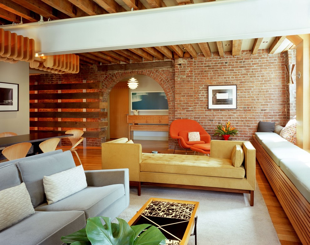 Foto di un grande soggiorno industriale con pavimento in legno massello medio