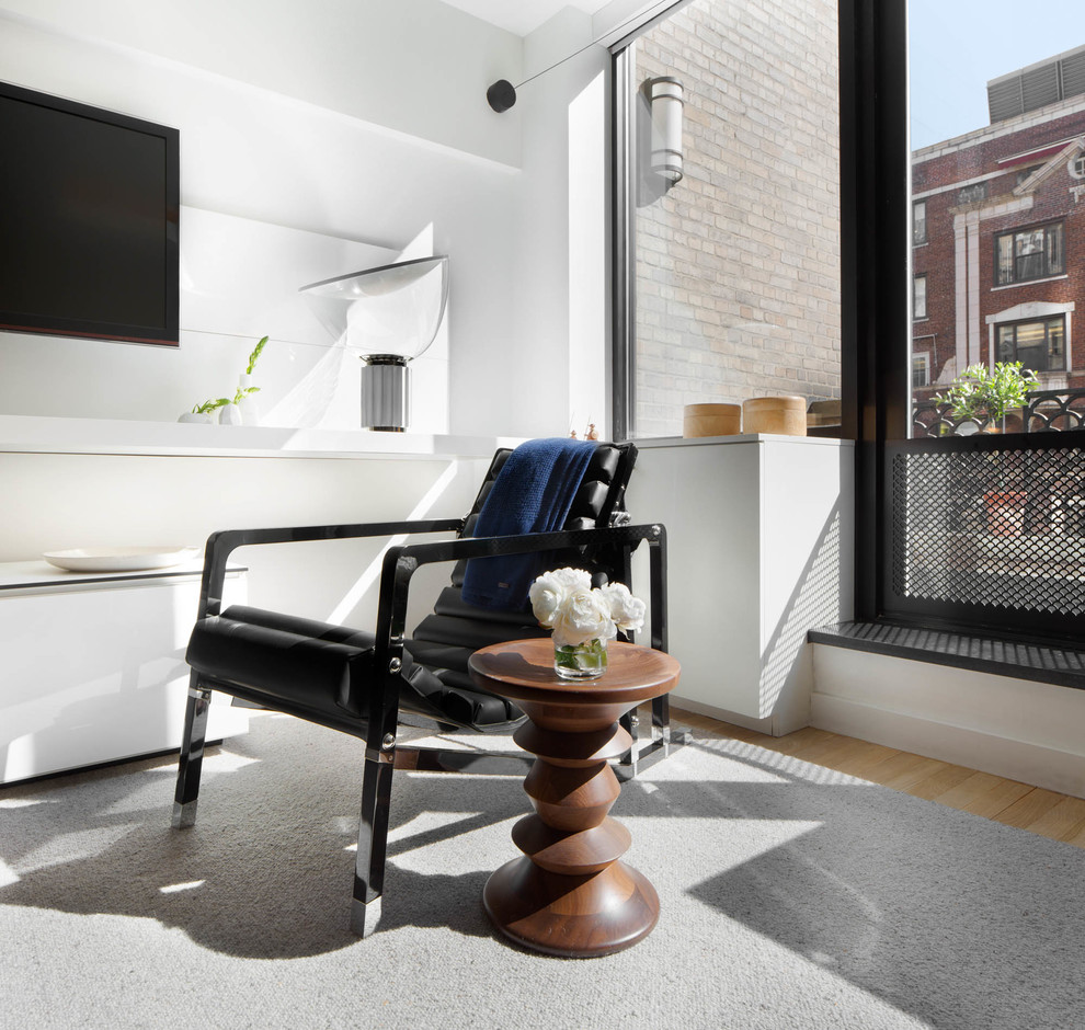 Пример оригинального дизайна: маленькая открытая гостиная комната в стиле модернизм с белыми стенами, светлым паркетным полом и телевизором на стене для на участке и в саду