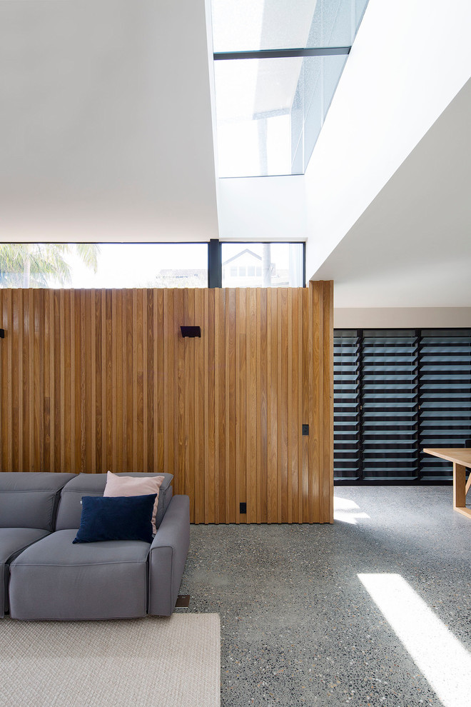 Immagine di un grande soggiorno design aperto con pareti bianche, pavimento in cemento e pavimento grigio