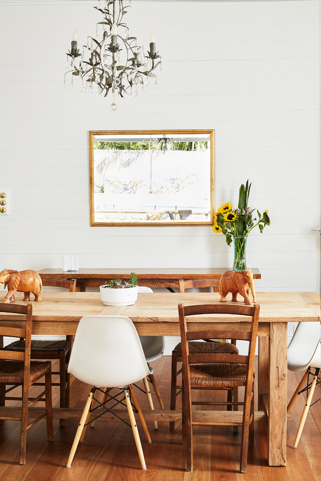 Immagine di una sala da pranzo chic di medie dimensioni con pareti bianche, pavimento in legno massello medio, camino ad angolo, cornice del camino in mattoni e pavimento marrone