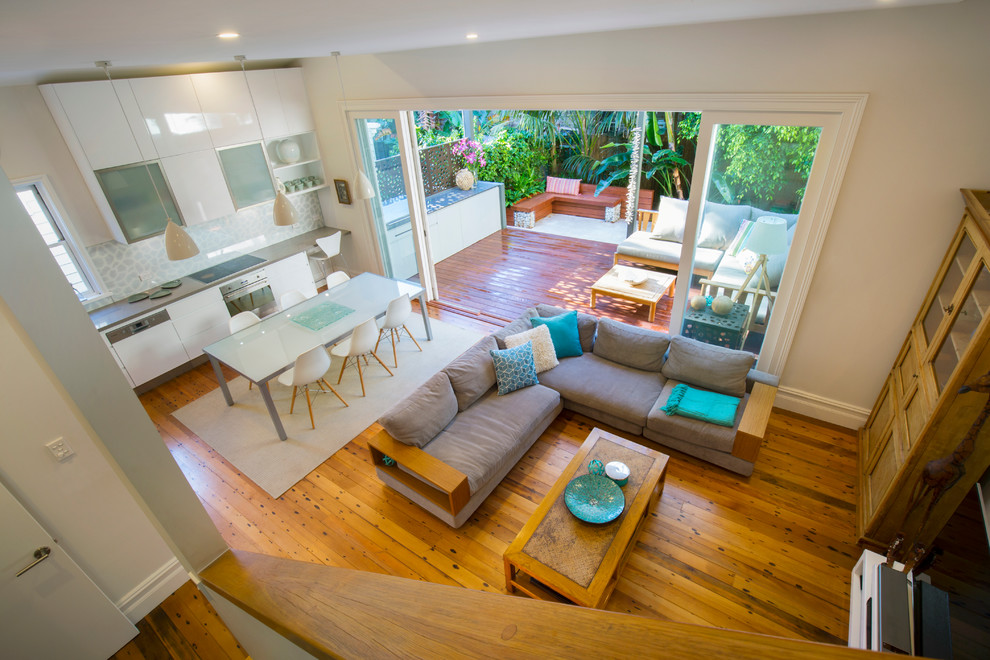 Foto di un soggiorno stile marino di medie dimensioni e aperto con pareti bianche, pavimento in legno massello medio e TV autoportante