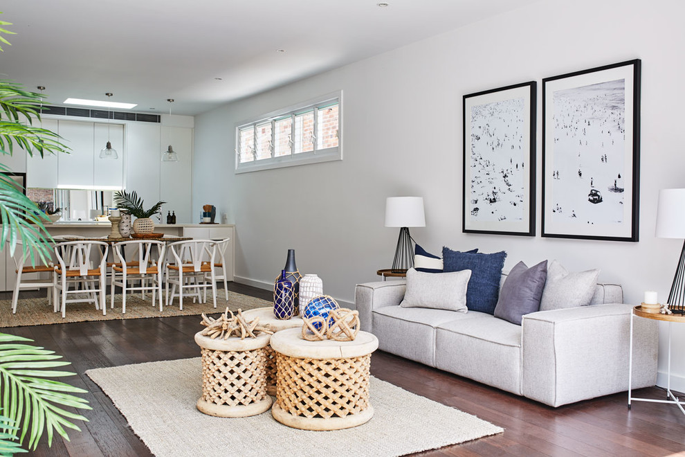 Offenes Maritimes Wohnzimmer ohne Kamin mit weißer Wandfarbe, dunklem Holzboden und freistehendem TV in Sydney