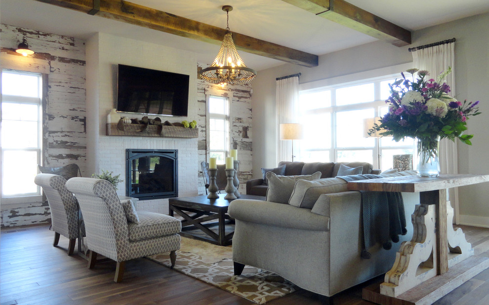 Esempio di un grande soggiorno classico aperto con pareti beige, pavimento in legno massello medio, sala formale e TV a parete