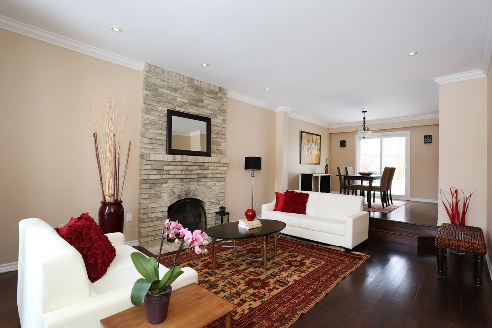 Cette photo montre un salon éclectique de taille moyenne et fermé avec un mur beige, parquet foncé et un manteau de cheminée en brique.