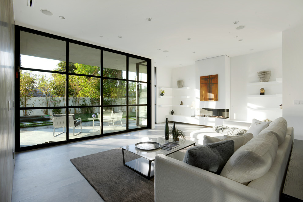 Example of a large trendy formal and open concept concrete floor living room design in Los Angeles with white walls, a standard fireplace, a plaster fireplace and no tv