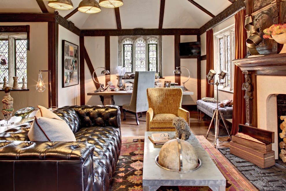 Example of an eclectic open concept medium tone wood floor living room design in New York with a standard fireplace and a wood fireplace surround
