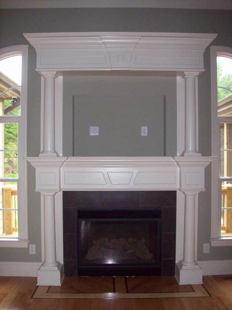Design ideas for a modern living room in Raleigh with a wooden fireplace surround.