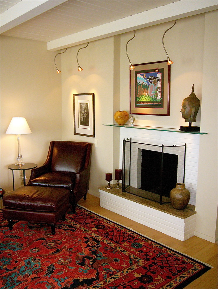 На фото: гостиная комната в стиле фьюжн с бежевыми стенами и стандартным камином