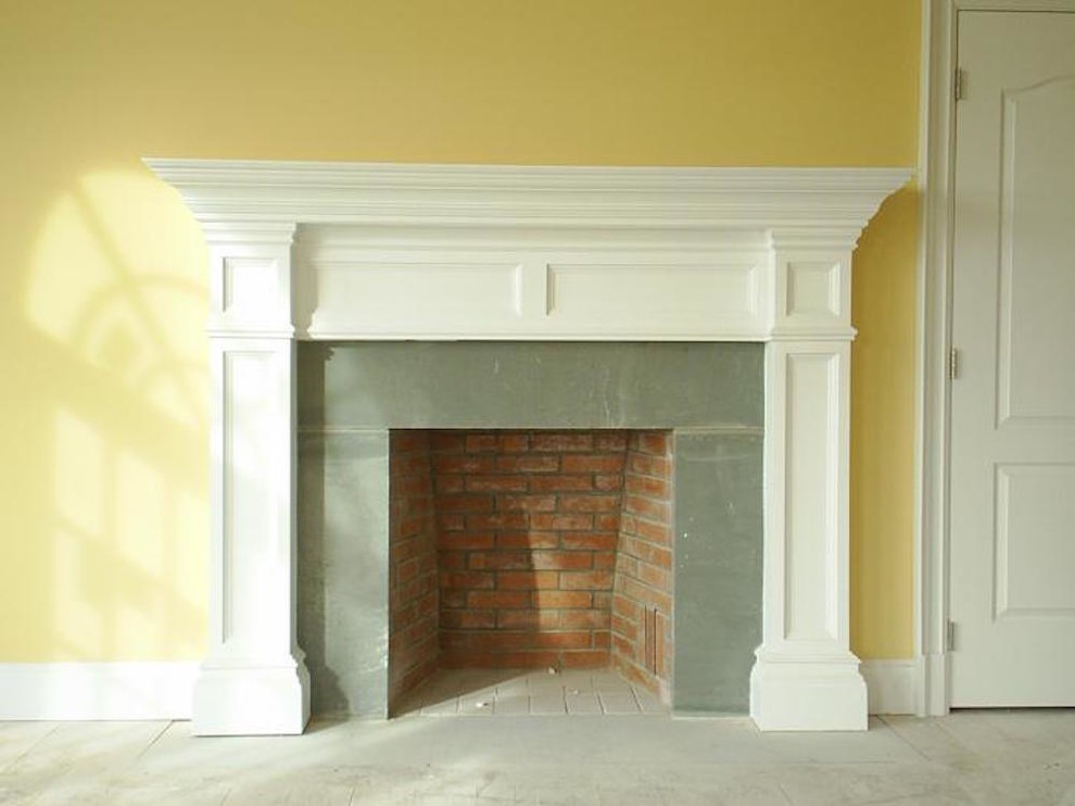 Пример оригинального дизайна: парадная, открытая гостиная комната среднего размера в классическом стиле с желтыми стенами, стандартным камином, фасадом камина из металла, бетонным полом и серым полом без телевизора