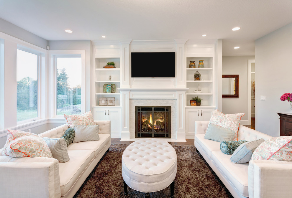 Inspiration for a large transitional open concept dark wood floor and brown floor family room remodel in New York with white walls, a standard fireplace, a wood fireplace surround and a wall-mounted tv