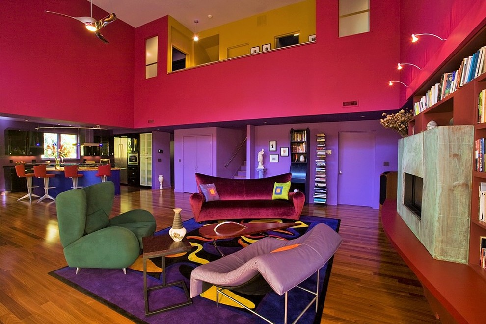 Diseño de salón abierto bohemio grande con paredes rosas, suelo de madera en tonos medios y chimenea lineal