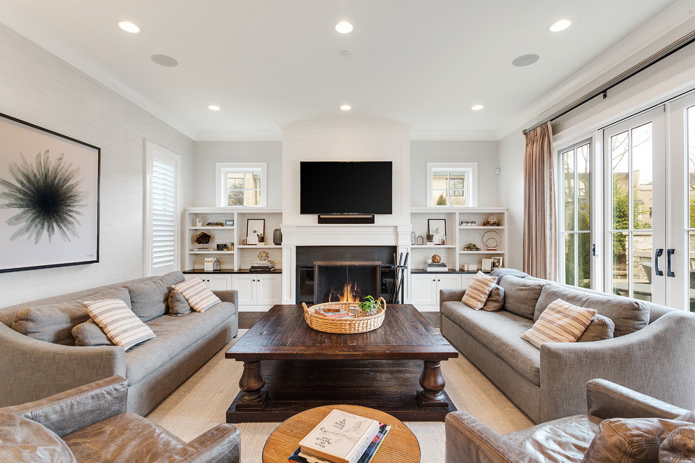 Exempel på ett klassiskt vardagsrum, med vita väggar, mörkt trägolv, en standard öppen spis, en spiselkrans i metall, en väggmonterad TV och brunt golv