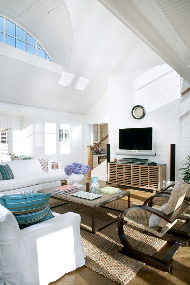 Пример оригинального дизайна: большая открытая гостиная комната в морском стиле с белыми стенами, паркетным полом среднего тона и телевизором на стене