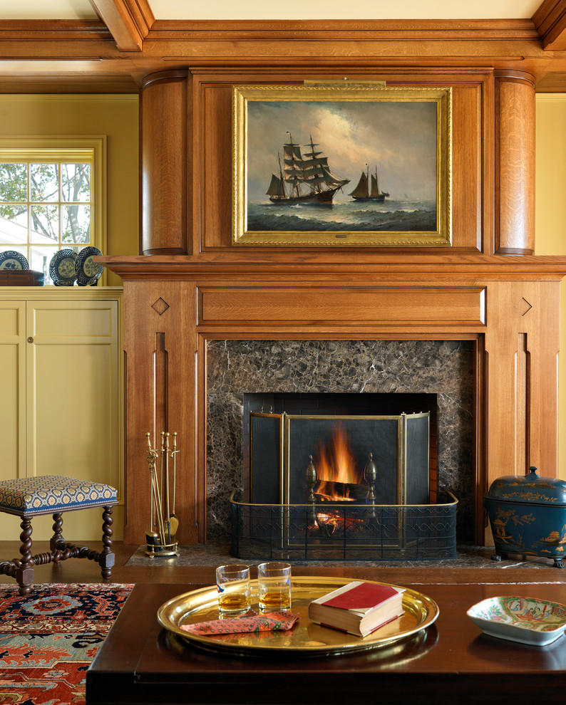 Repräsentatives Klassisches Wohnzimmer mit gelber Wandfarbe, braunem Holzboden, Kamin und Kaminumrandung aus Holz in Boston
