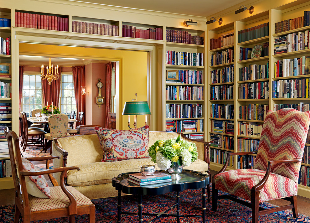 Immagine di un soggiorno vittoriano con libreria e pareti gialle