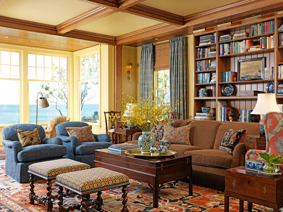 Cette image montre un salon victorien avec un mur jaune et une bibliothèque ou un coin lecture.