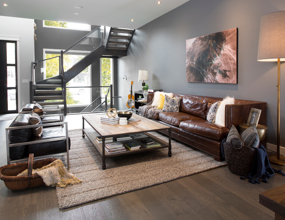 This is an example of a medium sized industrial open plan living room in Calgary with grey walls, dark hardwood flooring, a standard fireplace, a tiled fireplace surround and a freestanding tv.